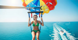 A person parasailing behind a boat, illustrating usage as an insurance factor.